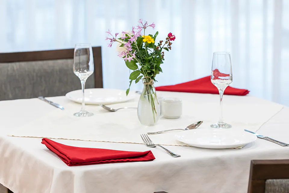 Dining table set with a flower vase and glasses
