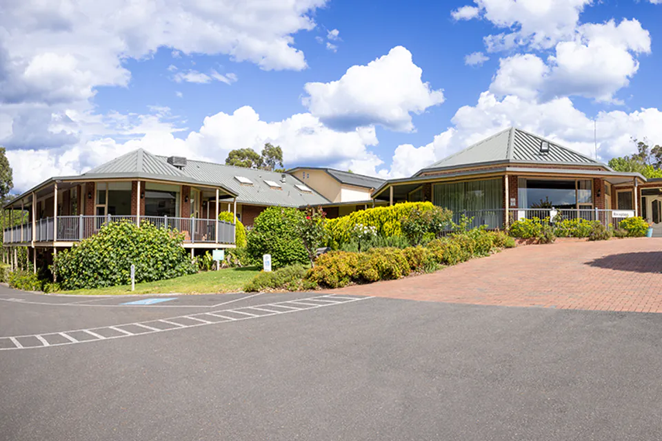Low-rise building and landscaped driveway overlooking hills